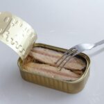 Sgombro in scatola su un tavolo, con verdure fresche e informazioni nutrizionali in evidenza.