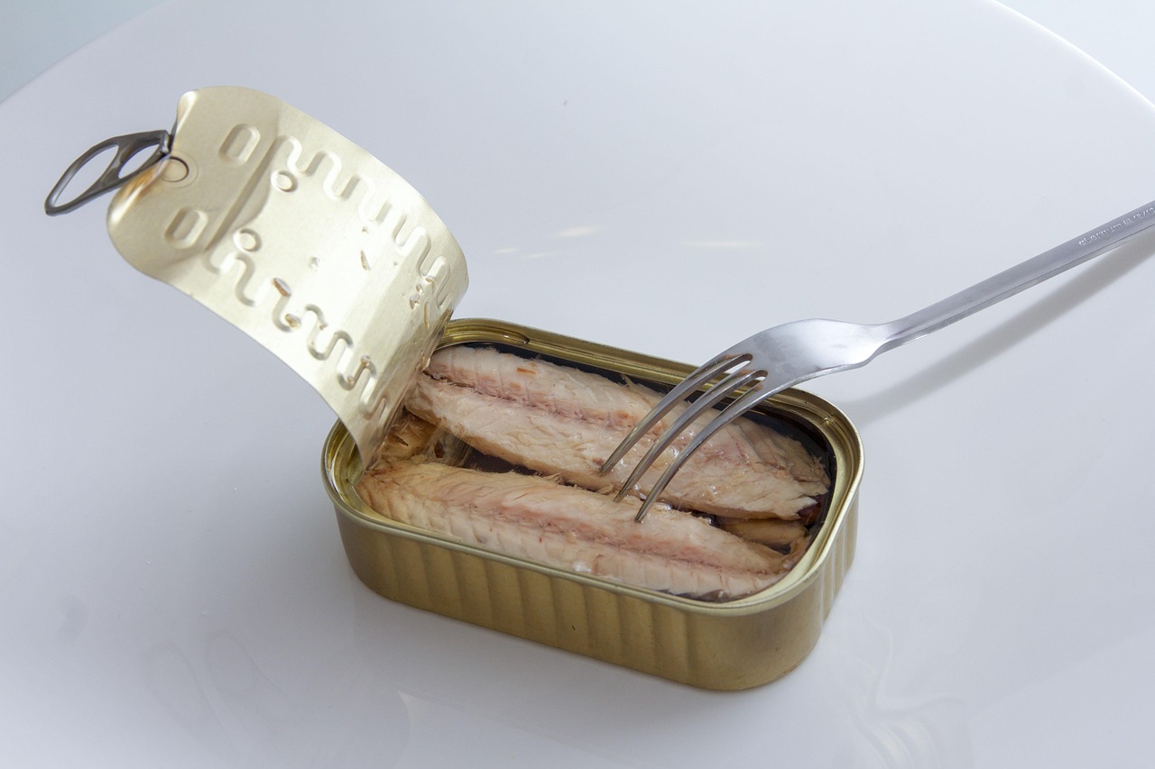 Sgombro in scatola su un tavolo, con verdure fresche e informazioni nutrizionali in evidenza.